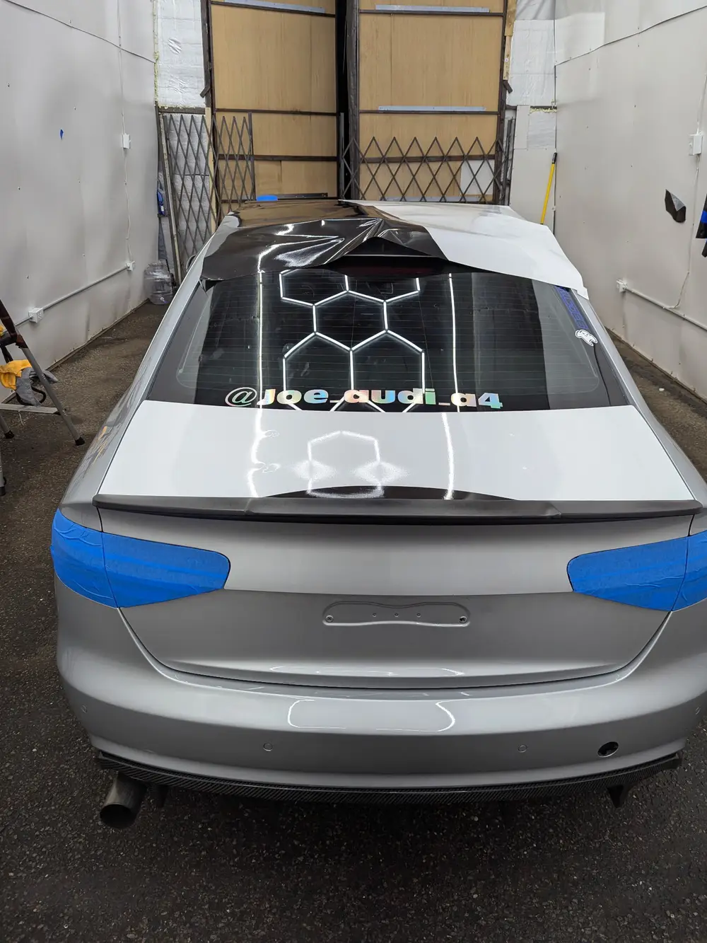 Livery being installed across the roof and rear glass in the WRP bay