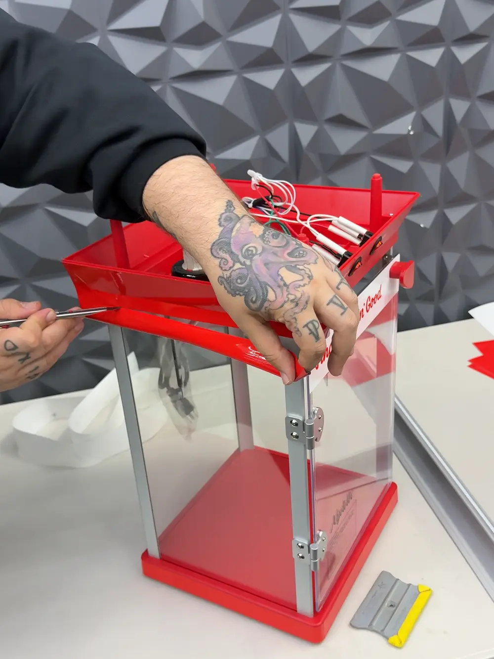 Hands assembling the KFC popcorn cart frame